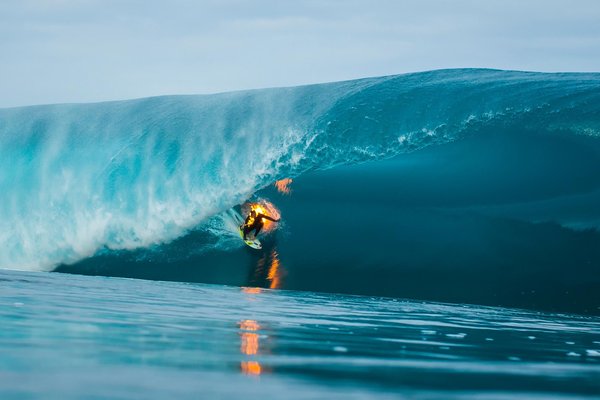 il surf une vague en étant en feu